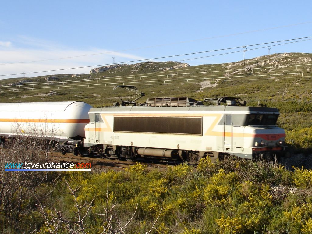 Une locomotive BB7200 en livrée Béton (la BB 7205) de l'activité FRET remorquant un train de wagons-citernes sur la ligne Marseille - Miramas